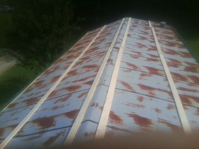 Rusted metal roof panels with new wood purlins before replacement — Storm Damage Roof Repair in Renfrew by Roofing Brothers