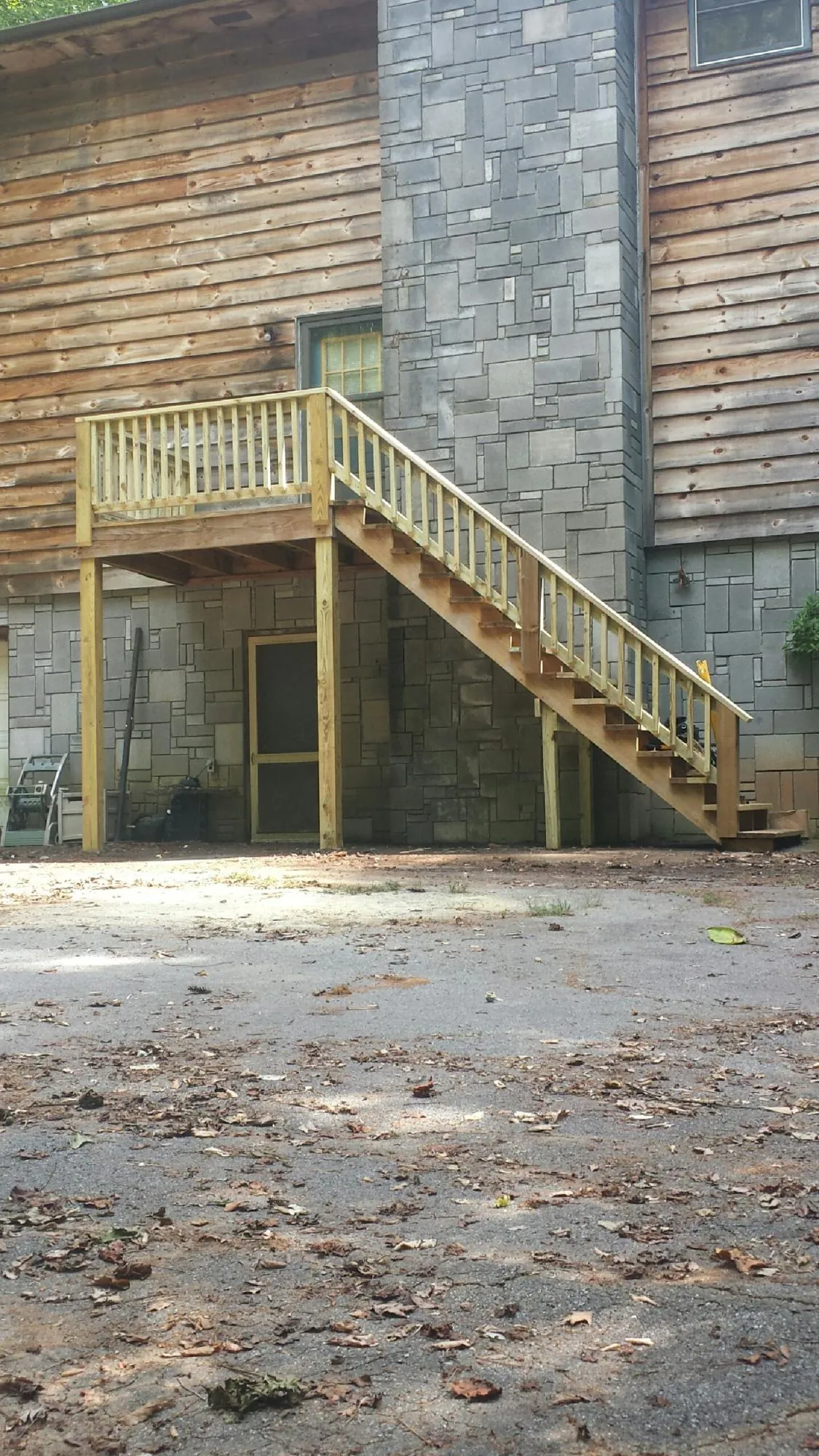 New pressure treated deck and stair landing on a log home in Renfrew