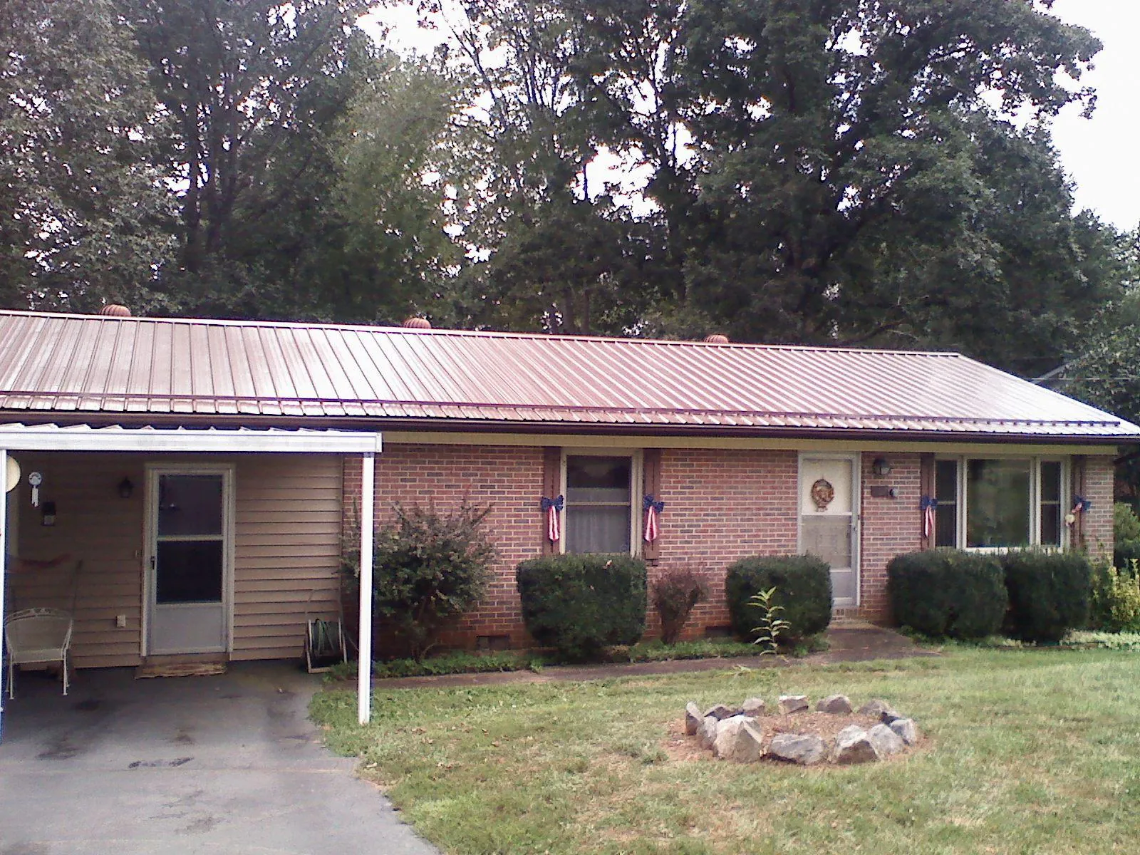 Bronze metal roof and carport on a brick ranch home — Roof Repair work by our crew in Renfrew